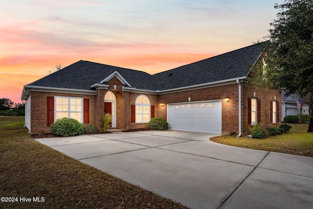 view of front facade featuring a garage and a lawn