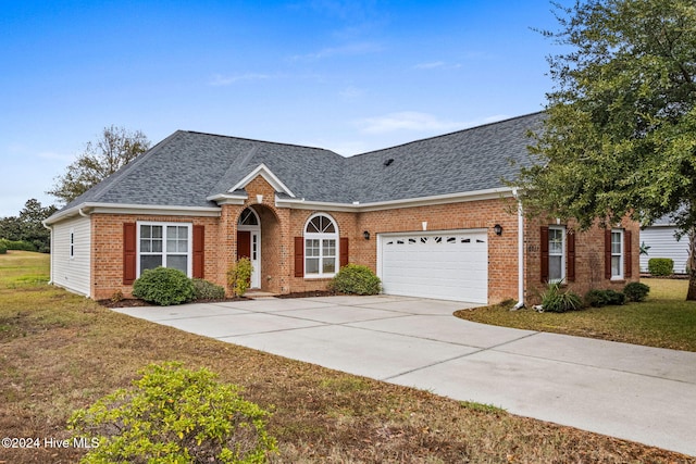 ranch-style house with a garage and a front lawn