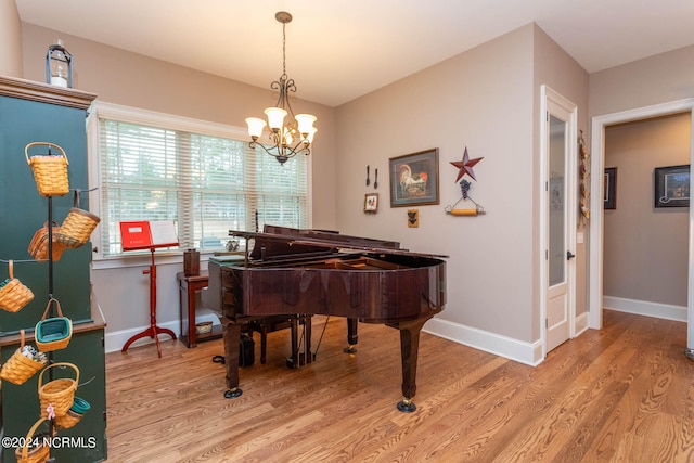 misc room featuring hardwood / wood-style floors and an inviting chandelier