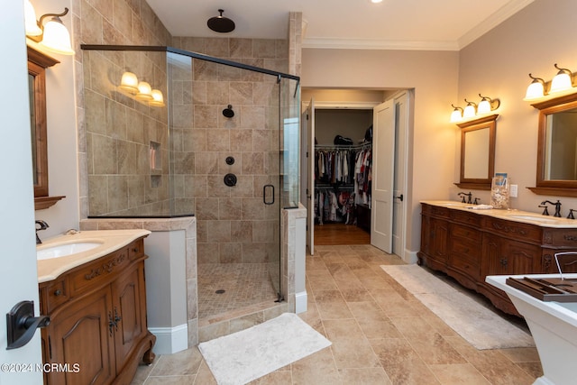 bathroom featuring vanity, a shower with shower door, and crown molding