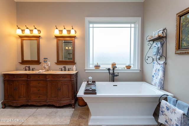 bathroom with tile patterned floors, a tub, a wealth of natural light, and vanity