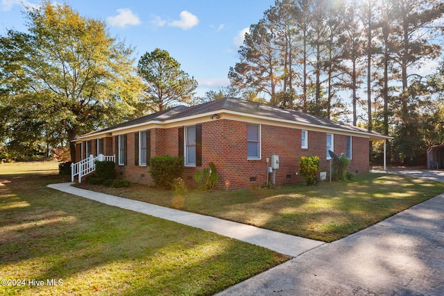 view of side of home featuring covered porch and a yard