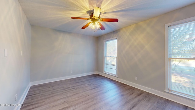 unfurnished room featuring hardwood / wood-style floors, plenty of natural light, and ceiling fan