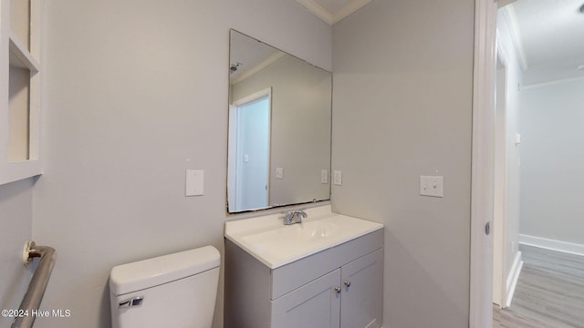 bathroom with toilet, vanity, and ornamental molding