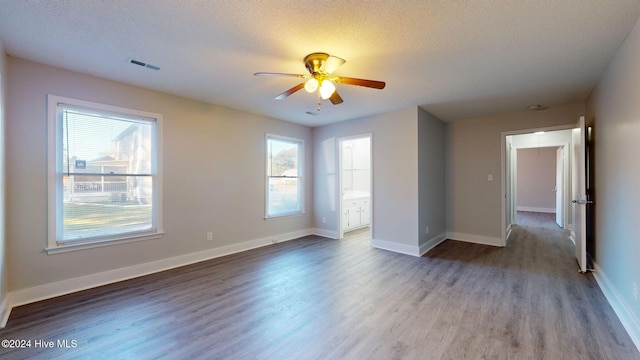 unfurnished room with ceiling fan, wood-type flooring, and a textured ceiling