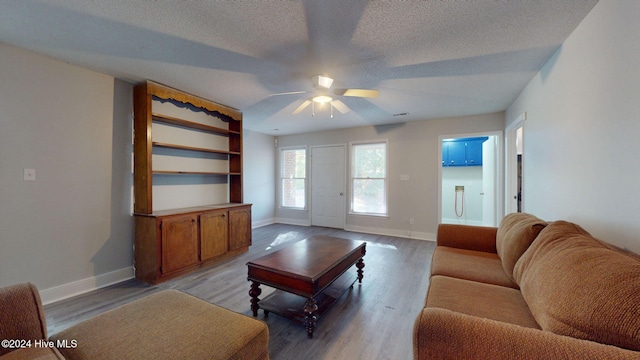 living room featuring a textured ceiling, hardwood / wood-style flooring, and ceiling fan