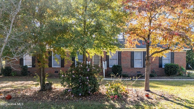 view of property hidden behind natural elements featuring a front yard