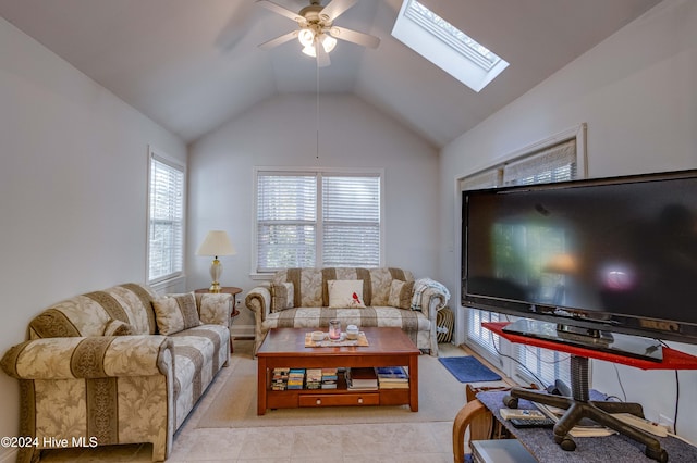 tiled living room featuring vaulted ceiling with skylight and ceiling fan