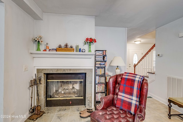 living area featuring light tile patterned floors and a tile fireplace