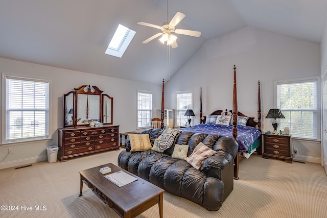 bedroom featuring high vaulted ceiling, light colored carpet, ceiling fan, and a skylight