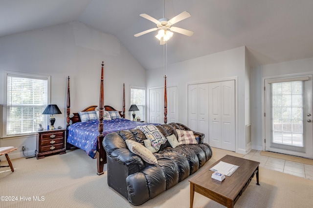 tiled bedroom with ceiling fan, multiple windows, access to exterior, and vaulted ceiling