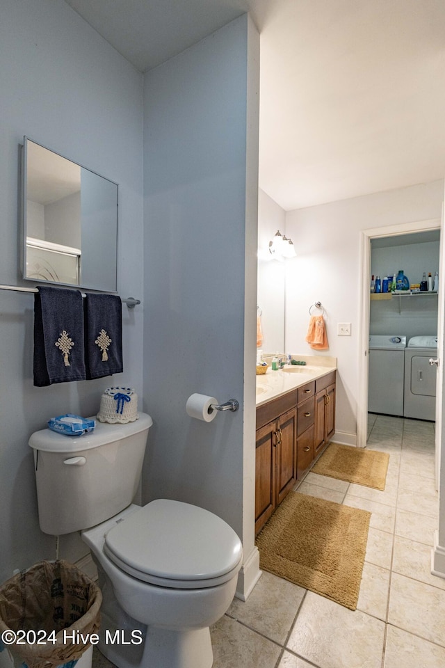 bathroom featuring separate washer and dryer, vanity, toilet, and tile patterned flooring