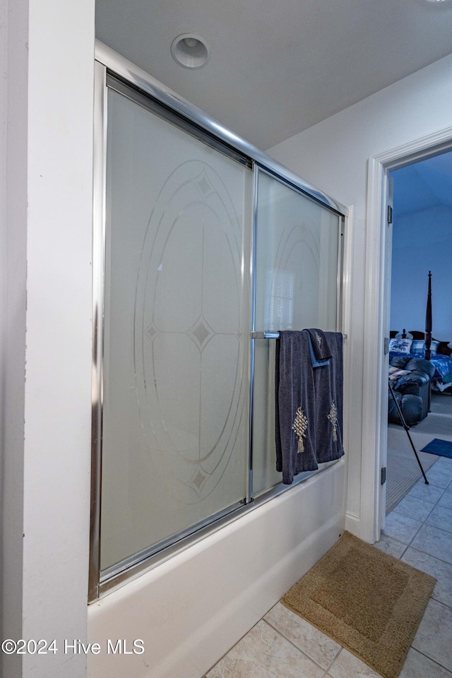 bathroom featuring combined bath / shower with glass door and tile patterned flooring