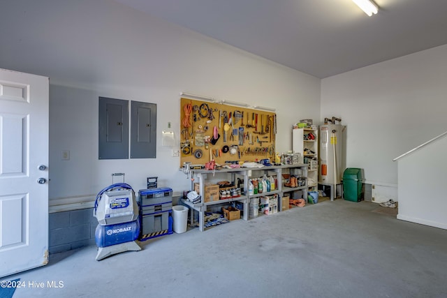 garage with a workshop area, water heater, and electric panel