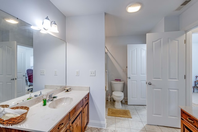 bathroom featuring tile patterned flooring, vanity, and toilet