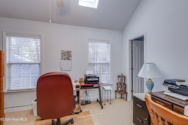 office space with light colored carpet, a healthy amount of sunlight, and vaulted ceiling with skylight