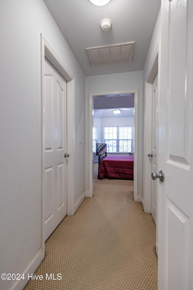 hallway featuring light colored carpet