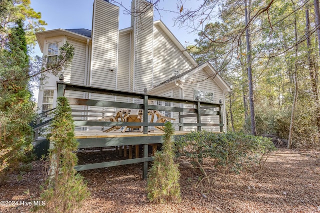 rear view of house featuring a wooden deck