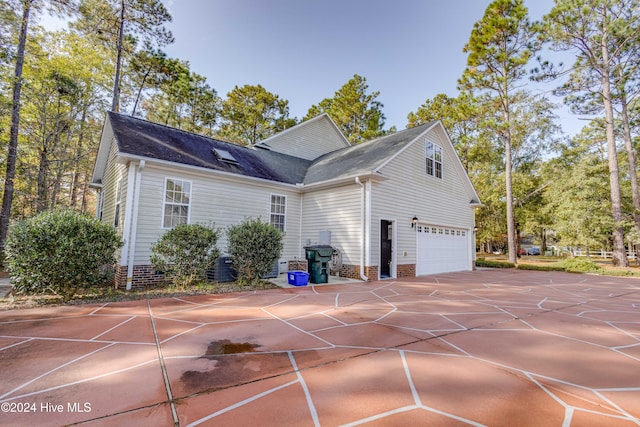 view of home's exterior with central air condition unit and a garage