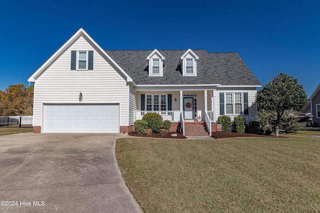 cape cod-style house featuring a front lawn, covered porch, and a garage