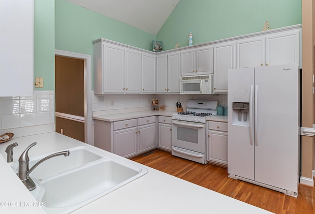 kitchen with decorative backsplash, white appliances, sink, light hardwood / wood-style floors, and white cabinetry