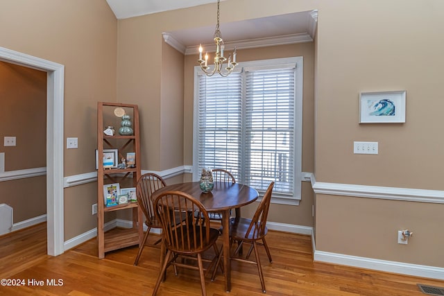 dining room featuring light wood-type flooring, a healthy amount of sunlight, and a notable chandelier