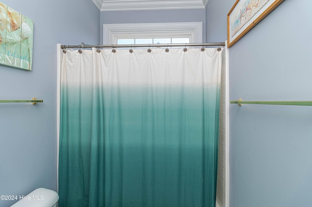 bathroom with a shower with curtain, toilet, and ornamental molding