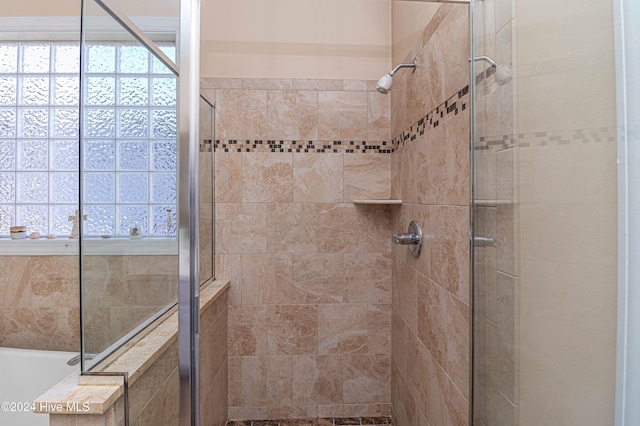 bathroom featuring shower with separate bathtub