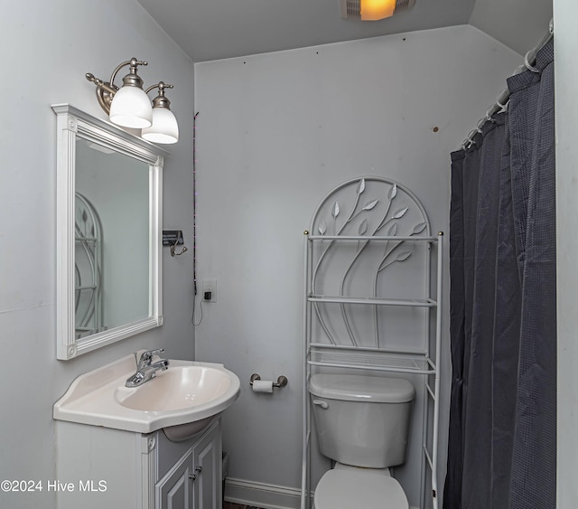 bathroom featuring walk in shower, vanity, vaulted ceiling, and toilet