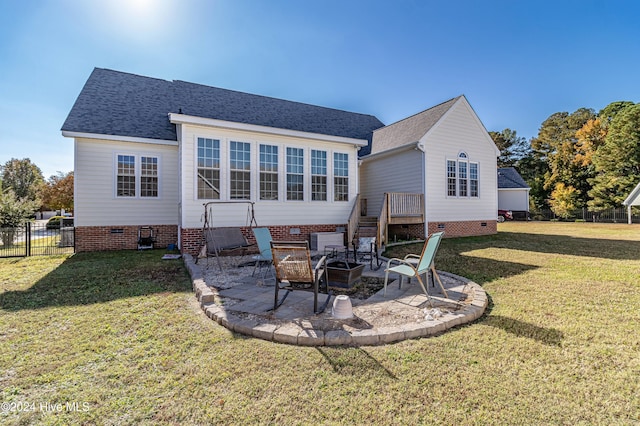 back of house with a lawn, a wooden deck, an outdoor fire pit, and a patio