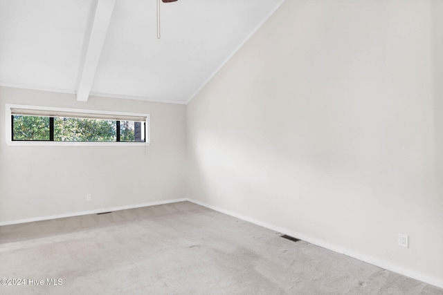 spare room with vaulted ceiling with beams and light carpet