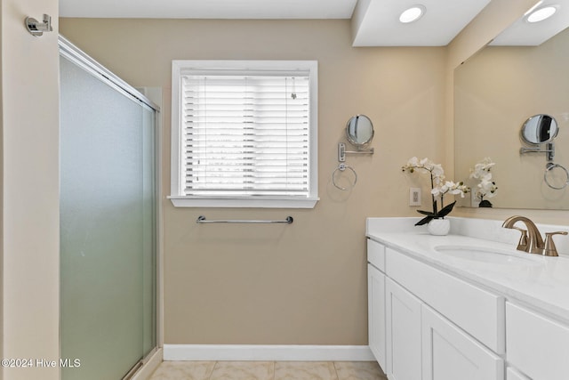 bathroom featuring tile patterned flooring, vanity, and walk in shower