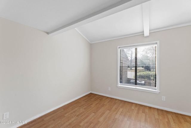 unfurnished room with beam ceiling and light hardwood / wood-style flooring