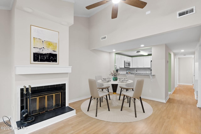 dining room with light hardwood / wood-style flooring, ceiling fan, and crown molding