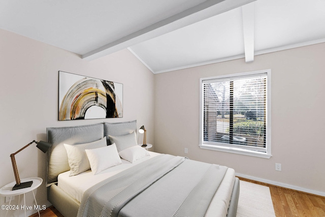 bedroom featuring vaulted ceiling with beams and hardwood / wood-style flooring