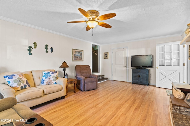 living room with ornamental molding, light wood-type flooring, a textured ceiling, and ceiling fan