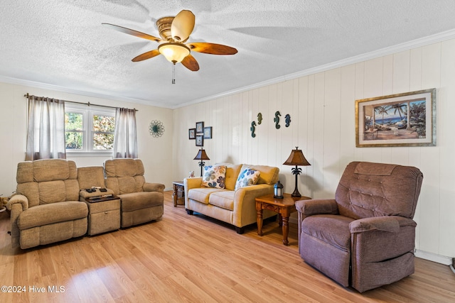 living room featuring a textured ceiling, ornamental molding, and light hardwood / wood-style flooring