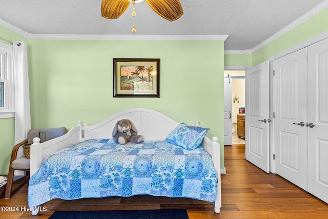 bedroom with ceiling fan, a textured ceiling, hardwood / wood-style floors, crown molding, and a closet