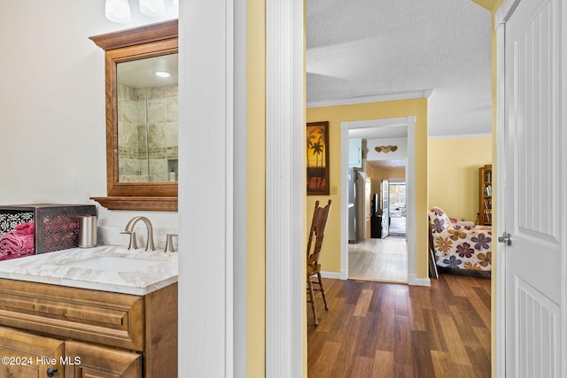 bathroom featuring crown molding, vanity, a textured ceiling, an enclosed shower, and hardwood / wood-style floors