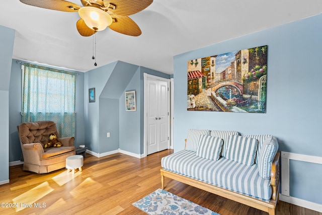 living area featuring wood-type flooring and ceiling fan