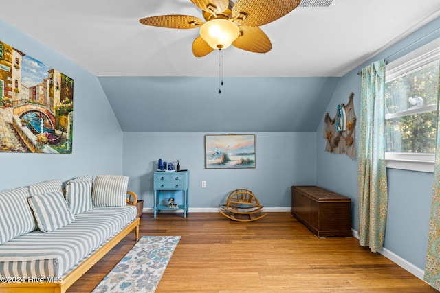 living area featuring light hardwood / wood-style floors, ceiling fan, and vaulted ceiling