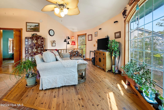 living room featuring vaulted ceiling, light hardwood / wood-style flooring, and ceiling fan