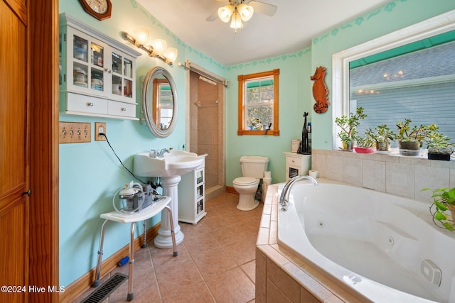 bathroom featuring tile patterned flooring, toilet, ceiling fan, and tiled tub