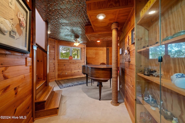 interior space featuring light tile patterned flooring and wood walls