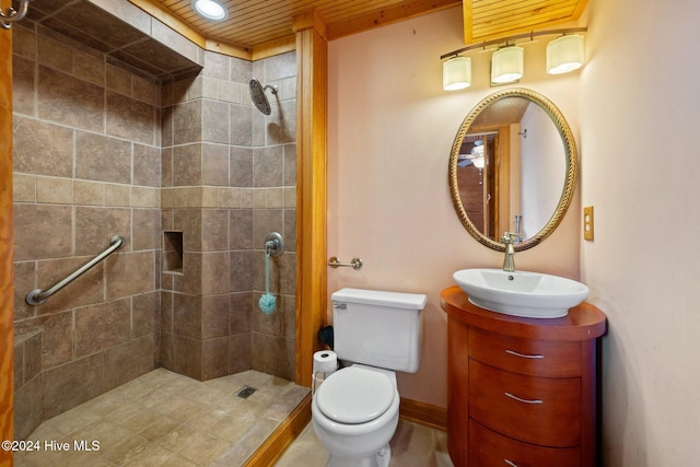 bathroom with vanity, toilet, and tiled shower