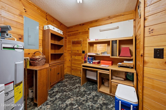 home office with wood walls, a textured ceiling, electric panel, and water heater