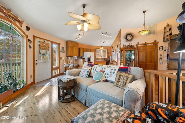 living room with light hardwood / wood-style floors, track lighting, and ceiling fan