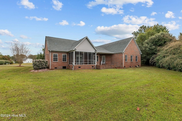 back of property with a sunroom and a yard