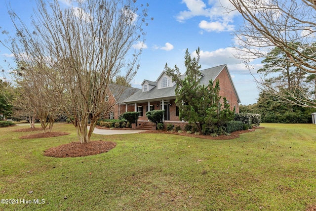 new england style home with covered porch and a front yard