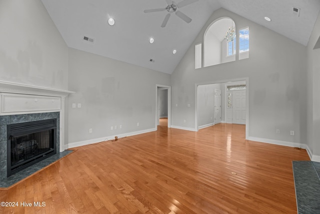 unfurnished living room featuring a fireplace, light wood-type flooring, high vaulted ceiling, and ceiling fan